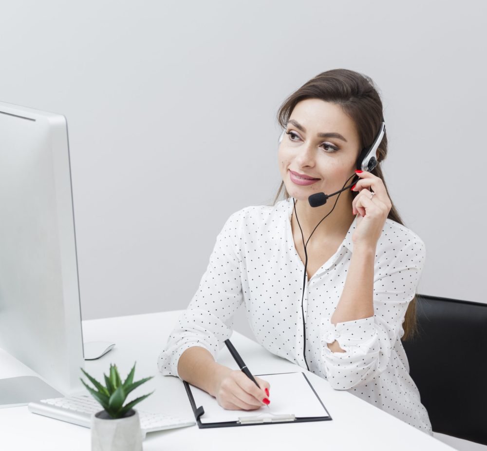 front-view-smiley-woman-writing-something-down-while-talking-headset